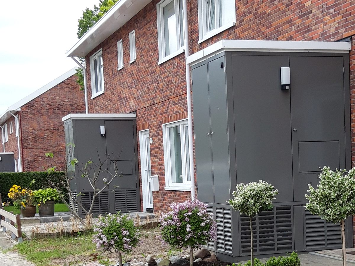 Rijwoningen in Woerden met de warmtepomp in een grijze kast tegen de voorgevel
